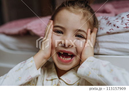 Portrait of cute girl smiling with gap-toothed grin, missing her baby teeth. 113157909