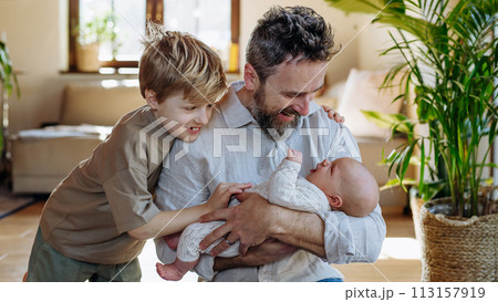 Father and boy holding newborn baby. New sibling. Unconditional paternal love, Father's Day concept. 113157919