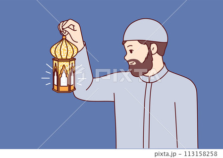 Muslim man holds arabic lantern, illuminating way at night to perform iftar and observe fast 113158258