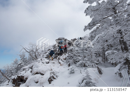 長野県茅野市の厳冬期の東天狗岳の渋ノ湯ルート(中山峠~東天狗)の青空と登山者と石と雪景色 長野県茅野市の厳冬期の東天狗岳の渋ノ湯ルート(中山峠~東天狗)の青空と登山者と石と雪景色 113158547