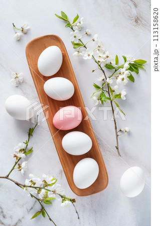 Wooden tray with white and pink eggs, flowers comfort food ingredients Wooden tray with white and pink eggs, flowers comfort food ingredients 113158620