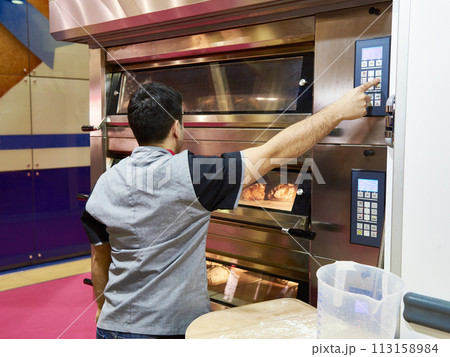 Man is baking bread in oven 113158984