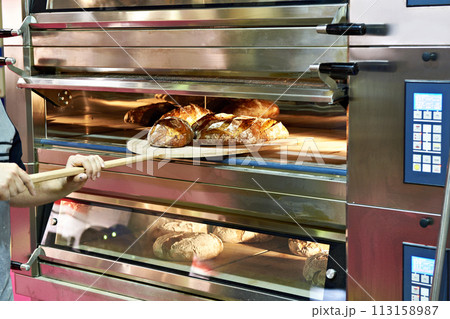 Man is baking bread in oven 113158987