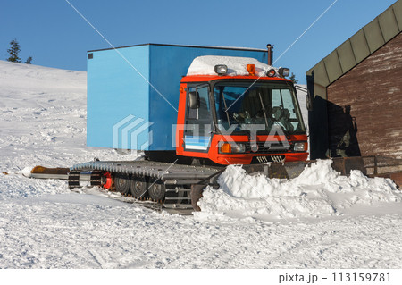 Red snowcat, fully tracked vehicle designed to move on snow in front of ski lodge in krkonose mountains, Czech Republic. Red snowcat, fully tracked vehicle designed to move on snow in front of ski lodge in krkonose mountains, Czech Republic. 113159781