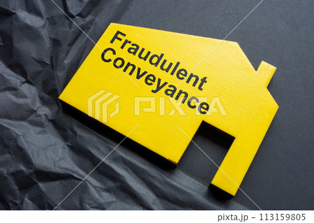 Crumpled paper and a figurine of a house with an inscription Fraudulent conveyance. 113159805