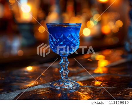 Refreshing Blue Cocktail in Glass on Bar Counter 113159910