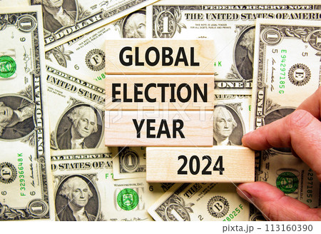 Global election year 2024 symbol. Concept words Global election year 2024 on beautiful block. Beautiful dollar bills background. Voter hand. Business Global election year 2024 concept. Copy space Global election year 2024 symbol. Concept words Global election year 2024 on beautiful block. Beautiful dollar bills background. Voter hand. Business Global election year 2024 concept. Copy space 113160390