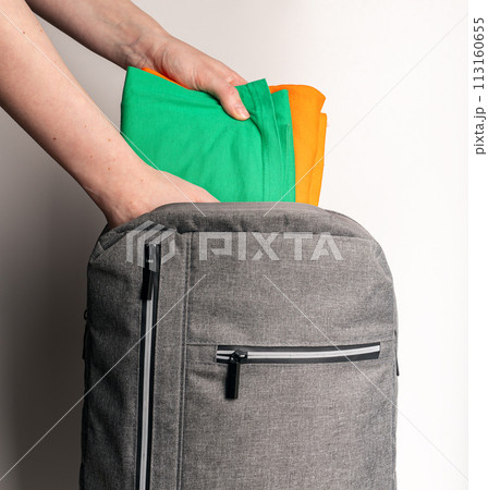 Packing clothes, garments into backpack Packing clothes, garments into backpack 113160655