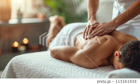 Relaxed young man receiving back massage in spa salon. Relaxing treatment concept 113161838