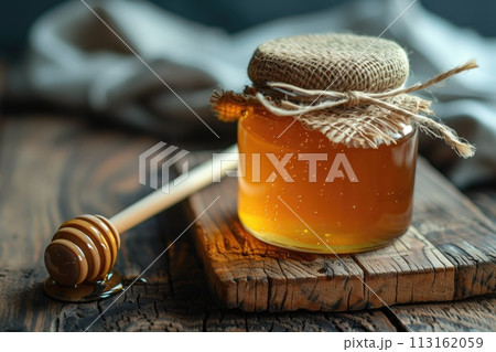 Gourmet honey with honeycomb and dipper on rustic wooden table 113162059