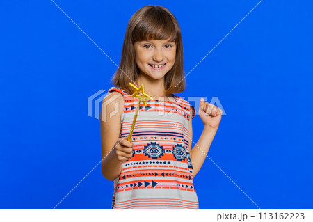 Child girl witch gesturing with magic wand fairy stick, making wish come true casting magician spell 113162223