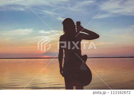 Joyful feeling satisfaction traveller, woman alone with acoustic guitar in summer time vacation leisure. pretty lady lifestyle. Joyful feeling satisfaction traveller, woman alone with acoustic guitar in summer time vacation leisure. pretty lady lifestyle. 113162672