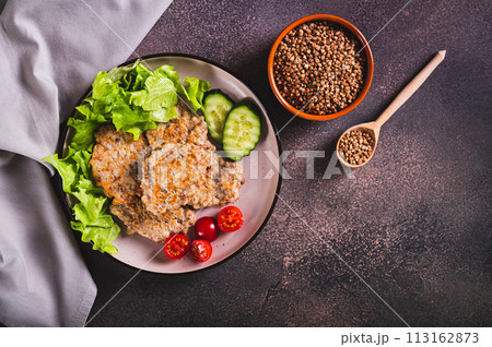 Spicy buckwheat pancakes with slices of cucumber, tomato and lettuce on a plate top view Spicy buckwheat pancakes with slices of cucumber, tomato and lettuce on a plate top view 113162873