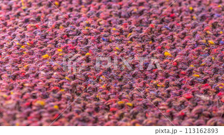 A close up of a knitted fabric with a variety of colors 113162893