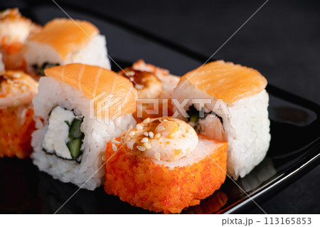 Set of Philadelphia sushi rolls on black plate. Serving Japanese food in restaurant. Popular Asian dish of rice and salmon. Uramaki rolls. 113165853