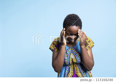 African american person laughing at a joke in studio, feeling happy and overjoyed while she wears a traditional tribal costume. Young woman enjoying leisure time and smiling on camera. African american person laughing at a joke in studio, feeling happy and overjoyed while she wears a traditional tribal costume. Young woman enjoying leisure time and smiling on camera. 113168280