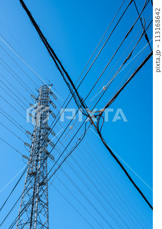 高圧送電鉄塔と交差する市街地の電線と快晴の空　b-1 113168642
