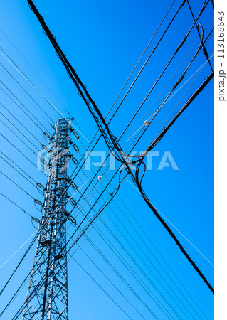 高圧送電鉄塔と交差する市街地の電線と快晴の空　b-2 高彩度コントラスト 113168643