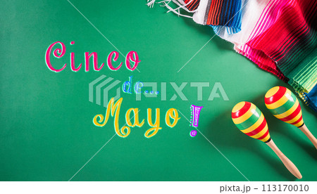 Cinco de Mayo holiday background made from maracas, mexican blanket stripes or poncho serape on green background. 113170010