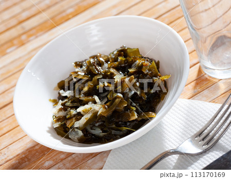 Healthy salad from marinated seaweed and onion served in plate with cutlery Healthy salad from marinated seaweed and onion served in plate with cutlery 113170169
