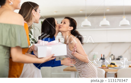 Group of women greeting each other and giving gift Group of women greeting each other and giving gift 113170347