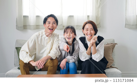 リビングルームでテレビを見ながら喜ぶ親子 113171084