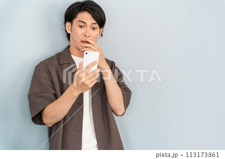 スマホを使う若いアジア人男性（炎上・びっくり・驚く・ショック・トラブル・事件・ニュース・株価） 113173861