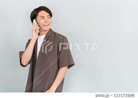 スマホで通話・電話する若いアジア人男性 スマホで通話・電話する若いアジア人男性 113173886