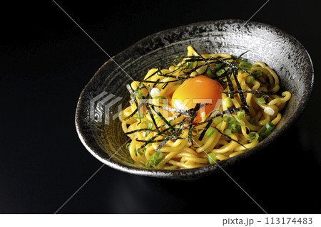 卵黄、刻み海苔、小ねぎが乗った油そばを黒背景で撮影 113174483
