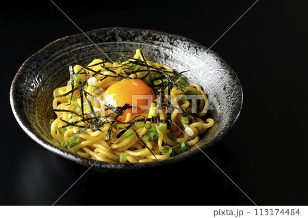 卵黄、刻み海苔、小ねぎが乗った油そばを黒背景で撮影 113174484