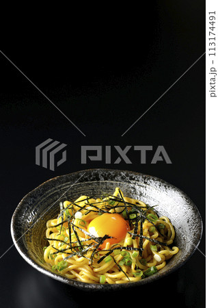 卵黄、刻み海苔、小ねぎが乗った油そばを黒背景で撮影 113174491