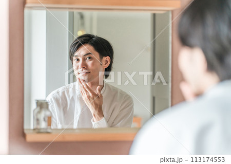 洗面所でシェービング後に剃り残しをチェックする男性(アフターシェービング・敏感肌・スキンケア) 洗面所でシェービング後に剃り残しをチェックする男性(アフターシェービング・敏感肌・スキンケア) 113174553