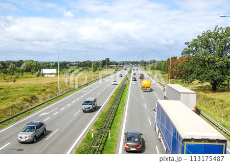 Aerial view of a highway with multiple lanes, showcasing the flow of traffic and the movement of cars and trucks, suitable for transportation infrastructure articles, traffic management reports 113175487