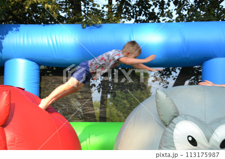 Joyful little girl playing on a trampoline. Joyful little girl playing on a trampoline. 113175987