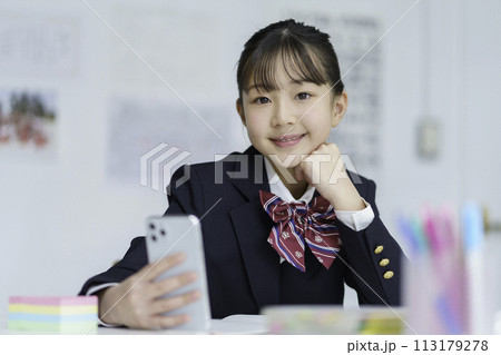 スマホを手に勉強をする女子学生のポートレート 113179278