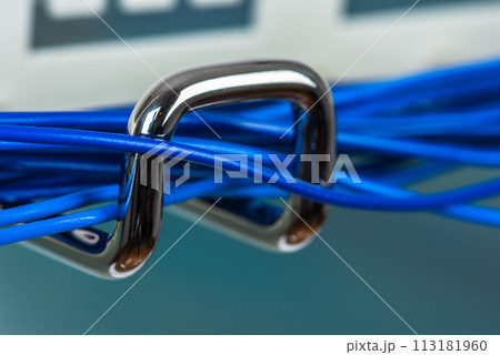 Electric cable cord on hook of organizer, macro view with blurred background Electric cable cord on hook of organizer, macro view with blurred background 113181960