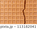 Broken spelt waffle with grid pattern as background 113182041