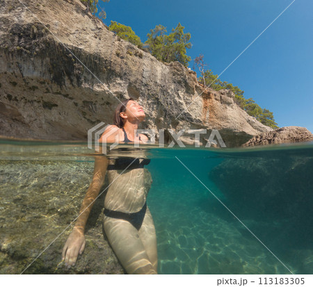 Woman on tropical vacation paradise on sea. Summer sea joy in Turkish seacoast, beaches along Lycian Way, Turkish Riviera. Asian female underwater and turquoise ocean around. Woman on tropical vacation paradise on sea. Summer sea joy in Turkish seacoast, beaches along Lycian Way, Turkish Riviera. Asian female underwater and turquoise ocean around. 113183305