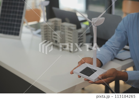 Close-up at tablet, Engineers pointing at tablet with their hands. To jointly design the use of renewable energy with wind and solar energy. Concept of using renewable energy. 113184265