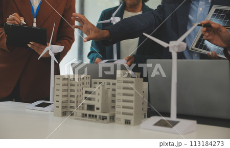 Close-up at tablet, Engineers pointing at tablet with their hands. To jointly design the use of renewable energy with wind and solar energy. Concept of using renewable energy. Close-up at tablet, Engineers pointing at tablet with their hands. To jointly design the use of renewable energy with wind and solar energy. Concept of using renewable energy. 113184273