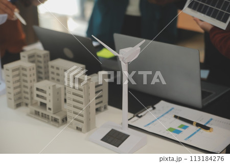 Close-up at tablet, Engineers pointing at tablet with their hands. To jointly design the use of renewable energy with wind and solar energy. Concept of using renewable energy. Close-up at tablet, Engineers pointing at tablet with their hands. To jointly design the use of renewable energy with wind and solar energy. Concept of using renewable energy. 113184276