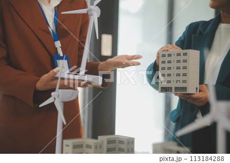 Close-up at tablet, Engineers pointing at tablet with their hands. To jointly design the use of renewable energy with wind and solar energy. Concept of using renewable energy. Close-up at tablet, Engineers pointing at tablet with their hands. To jointly design the use of renewable energy with wind and solar energy. Concept of using renewable energy. 113184288