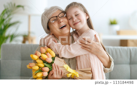 Grandma and girl smiling and hugging 113184498