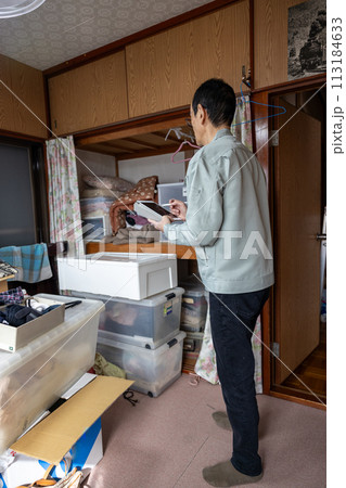 実家じまいで業者に不用品の買取査定をしてもらっているところ 113184633