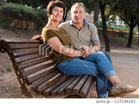 elderly man and woman embracing on bench elderly man and woman embracing on bench 113186281