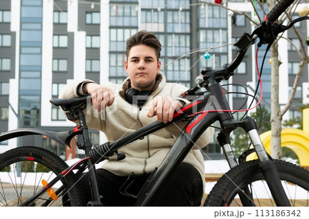 A handsome young guy stopped to rest while cycling 113186342
