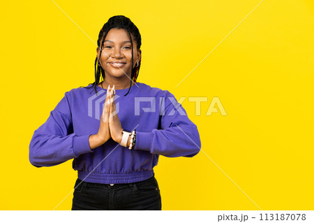 Woman Making Gesture of Gratitude in Purple Sweater 113187078