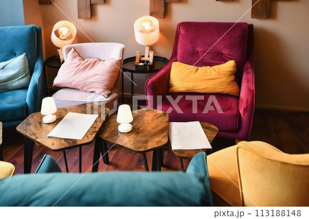 Cozy restaurant with armchairs and cushions for an aperitif 113188148