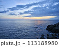 美しい夕焼けの空と青い海と岩 113188980