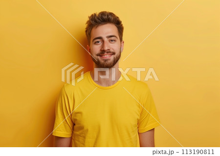 A man in a yellow shirt is smiling and looking at the camera 113190811
